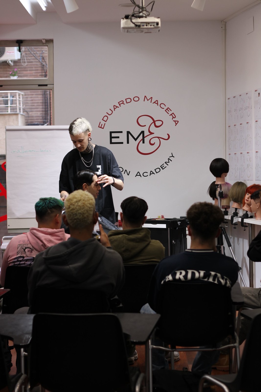 Alberto impartiendo una demostración de barbería ante un grupo de alumnos