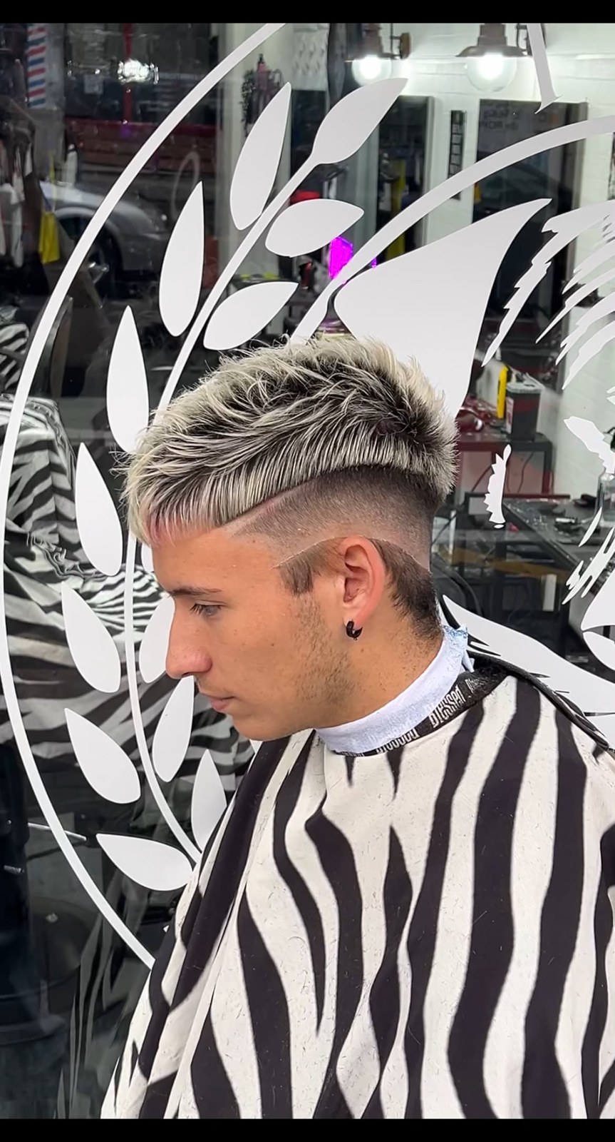 Corte con cabello claro, raíz oscura y diseño lateral